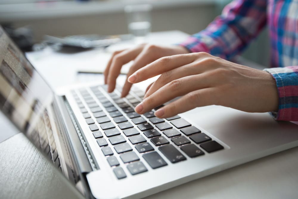 cropped-view-of-hands-typing-on-laptop