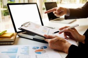 people-cooperation-accountant-consulting-accounting-pointing-scaled mains expliquant tableau de reporting compta